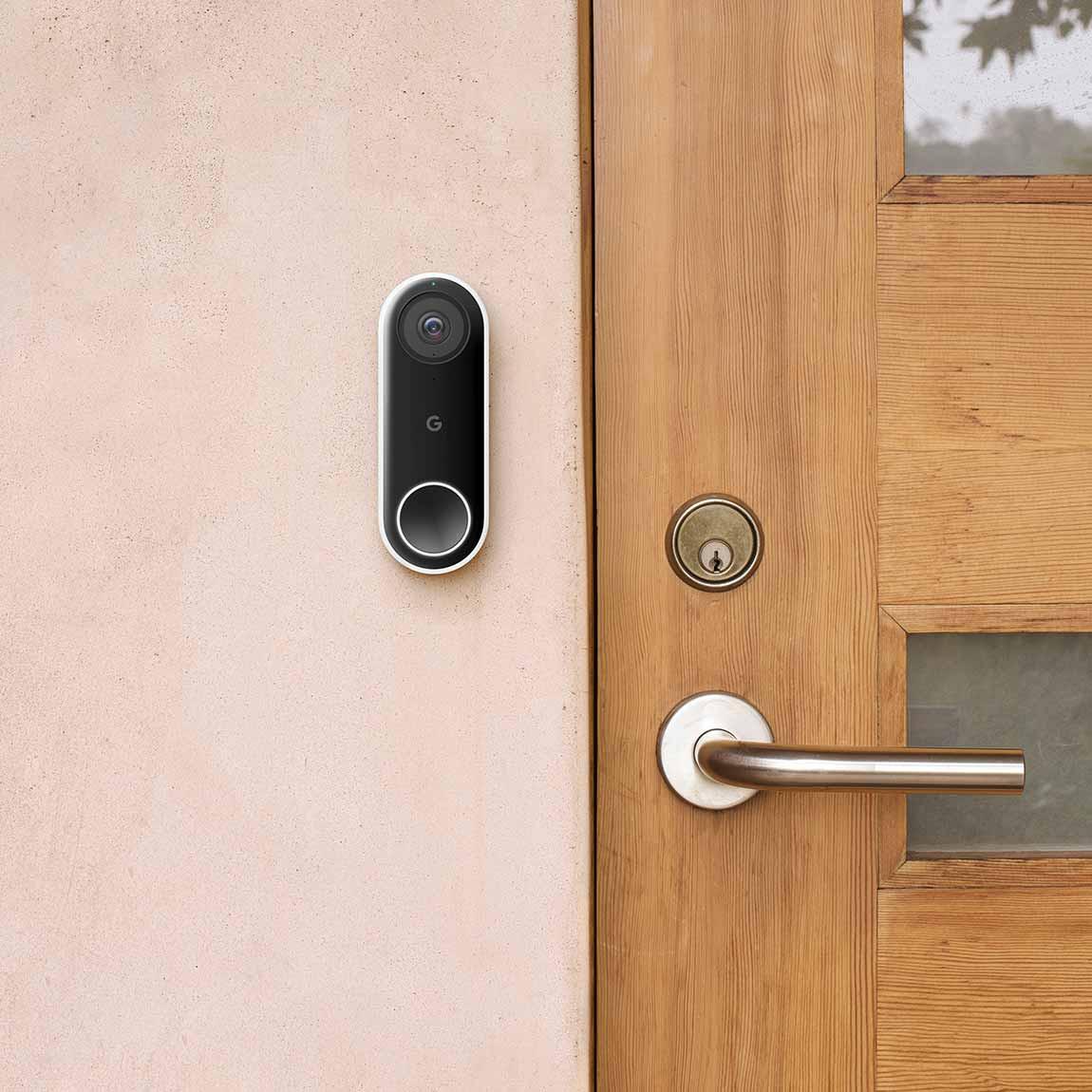 Google Nest Doorbell (Mit Kabel) - smarte Türklingel an der Wand neben hölzerner Haustür